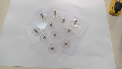 Various screws of different shapes and sizes arranged on a white sheet of paper.